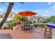 Patio area with outdoor dining set, umbrella, and lush landscaping for relaxed outdoor living at 3482 W Shannon St, Chandler, AZ 85226