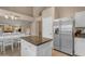 Kitchen featuring a stainless steel refrigerator, white cabinets, granite countertops, and a central island at 3482 W Shannon St, Chandler, AZ 85226