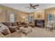 Cozy living room featuring a fireplace, comfortable seating, soft lighting, and a ceiling fan for added comfort at 3482 W Shannon St, Chandler, AZ 85226