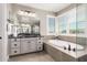 Bright bathroom featuring a soaking tub and large vanity with granite countertops at 3623 E Arabian Dr, Gilbert, AZ 85296