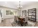 Elegant dining room with modern chandelier, stylish shelving, and large windows at 3623 E Arabian Dr, Gilbert, AZ 85296