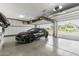 Spacious garage with epoxy flooring, white cabinetry, and a sleek black car at 3623 E Arabian Dr, Gilbert, AZ 85296