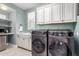 Efficient laundry room with modern washer and dryer, ample cabinet space and sink at 3623 E Arabian Dr, Gilbert, AZ 85296