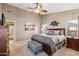 Main bedroom features a ceiling fan, carpet flooring, ensuite bathroom, and walk-in closet at 3711 N 162Nd Ln, Goodyear, AZ 85395