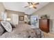 Main bedroom features a ceiling fan, carpet flooring, and a view of the backyard at 3711 N 162Nd Ln, Goodyear, AZ 85395