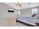 Neutral colored bedroom with a large television, ceiling fan, and windows with light-filtering shutters at 38572 N Jessica Ln, San Tan Valley, AZ 85140