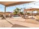 Inviting backyard pool area with a covered patio, lounge furniture, and lush tropical landscaping at 38572 N Jessica Ln, San Tan Valley, AZ 85140