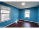 Bedroom with two bright windows and dark wood-look floors at 40564 W Nicole Ct, Maricopa, AZ 85138