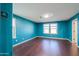 A blue-walled bedroom with dark hardwood floors, two windows and an ecobee thermostat at 40564 W Nicole Ct, Maricopa, AZ 85138