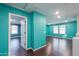 Upstairs hallway with hardwood floors, turquoise walls, and a view into two bedrooms with natural lighting at 40564 W Nicole Ct, Maricopa, AZ 85138