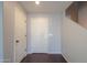 Hallway view with light gray walls, hardwood floors, a white door, and staircase at 40564 W Nicole Ct, Maricopa, AZ 85138