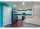 Modern kitchen with white cabinets, stainless steel appliances, and a bright turquoise backsplash at 40564 W Nicole Ct, Maricopa, AZ 85138