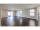 Spacious living room featuring hardwood floors, light gray walls, and natural light from backyard at 40564 W Nicole Ct, Maricopa, AZ 85138