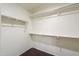 An empty walk-in closet with white walls, shelving and hardwood floors at 40564 W Nicole Ct, Maricopa, AZ 85138