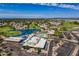 Aerial view of the community clubhouse, pool, parking lot, pond, and golf course at 422 S 76Th Way, Mesa, AZ 85208