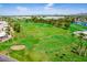 An aerial perspective showing the golf course with mature trees and a water feature at 422 S 76Th Way, Mesa, AZ 85208