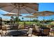 View of the patio with tables and umbrellas overlooking the golf course at 422 S 76Th Way, Mesa, AZ 85208