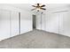 This bedroom features a ceiling fan, neutral carpet, and closet space at 4233 E Covina St, Mesa, AZ 85205