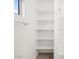 Bathroom features built in shelving, shower with white tiling, and a window at 4265 W Hannah St, San Tan Valley, AZ 85144