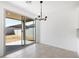 Dining area features neutral tile flooring, sliding glass door, and modern chandelier at 4265 W Hannah St, San Tan Valley, AZ 85144