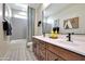 Bright bathroom featuring double sinks, modern fixtures, patterned tile floors, and a shower and tub combination at 44327 N 43Rd Dr, Phoenix, AZ 85087