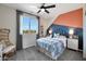 Well-lit bedroom featuring colorful accent wall, plush carpet, ceiling fan, and a view of the landscape outside at 44327 N 43Rd Dr, Phoenix, AZ 85087