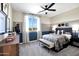 Comfortable bedroom with an accent wall, plush carpet, ceiling fan, and a view of the landscape outside at 44327 N 43Rd Dr, Phoenix, AZ 85087