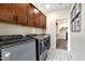 Functional laundry room with side-by-side washer and dryer, ample storage, and stylish patterned flooring at 44327 N 43Rd Dr, Phoenix, AZ 85087