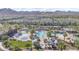 Aerial shot showcases the community pool, lounge areas, and play areas with palm trees and mountain views at 4651 N 204Th Ave, Buckeye, AZ 85396