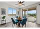 Dining area with a round table, blue chairs, and views of the backyard patio at 4651 N 204Th Ave, Buckeye, AZ 85396