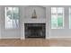 Close-up of a living room fireplace with tile surround, wood floors, and bright natural light from nearby windows at 473 S Ash St, Gilbert, AZ 85233