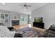 Well-lit living room featuring a fireplace, hardwood floors, neutral walls, ceiling fan, and cozy gray sofas at 473 S Ash St, Gilbert, AZ 85233