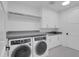 Bright laundry room with modern washer and dryer and white cabinetry at 5000 N Camelback Ridge Dr # 409, Scottsdale, AZ 85251