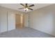 Bedroom featuring neutral carpet, ceiling fan, and double door entry at 509 W Princeton Ave, Gilbert, AZ 85233