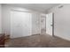 Bedroom with carpet flooring featuring bi-fold closet doors and an open doorway at 5318 W Aire Libre Ave, Glendale, AZ 85306