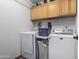 Laundry room includes full sized washer and dryer with overhead storage at 5318 W Aire Libre Ave, Glendale, AZ 85306