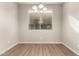 Bright dining room featuring laminate flooring, a modern light fixture and a sunlit window at 5430 W Odeum Ln, Phoenix, AZ 85043