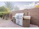 Backyard barbecue station with stainless steel grill and brick and granite serving area at 5921 E Ocupado Dr, Cave Creek, AZ 85331