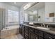 Elegant bathroom with double sinks, granite countertops, a large soaking tub, and ample natural light at 5921 E Ocupado Dr, Cave Creek, AZ 85331