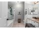 Bright bathroom with white vanity, bathtub, glass shower, neutral walls, and tile flooring at 6401 W Irma Ln, Glendale, AZ 85308