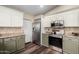 Well-lit kitchen with stainless steel appliances and neutral earth-toned backsplash at 6401 W Irma Ln, Glendale, AZ 85308