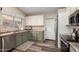 Well-lit kitchen with updated appliances, natural light, mosaic backsplash, and modern stainless steel dishwasher at 6401 W Irma Ln, Glendale, AZ 85308