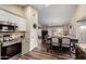 Open concept kitchen and dining area with stainless steel appliances, pendant lighting, and warm color tones at 6401 W Irma Ln, Glendale, AZ 85308