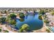 Scenic view of a large pond surrounded by lush trees and vegetation, in a serene neighborhood setting at 6401 W Irma Ln, Glendale, AZ 85308