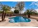 Stunning kidney-shaped pool surrounded by lush landscaping, creating a private backyard oasis at 6401 W Irma Ln, Glendale, AZ 85308