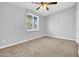 This bedroom features neutral carpeting, a ceiling fan, and a sun-drenched window at 6524 N 13Th St, Phoenix, AZ 85014