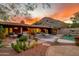 Sunset view of backyard with covered seating area, pool, and desert landscaping at 6845 N Hillside Dr, Paradise Valley, AZ 85253