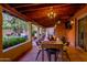 Relaxing covered patio area with an inviting dining table setup and serene views of the lush, landscaped yard at 6845 N Hillside Dr, Paradise Valley, AZ 85253