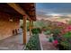 Charming covered porch with comfortable seating surrounded by vibrant flowers and desert landscaping at 6845 N Hillside Dr, Paradise Valley, AZ 85253