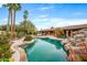 Backyard featuring a sparkling pool with a rock waterfall and lush landscaping at 6845 N Hillside Dr, Paradise Valley, AZ 85253